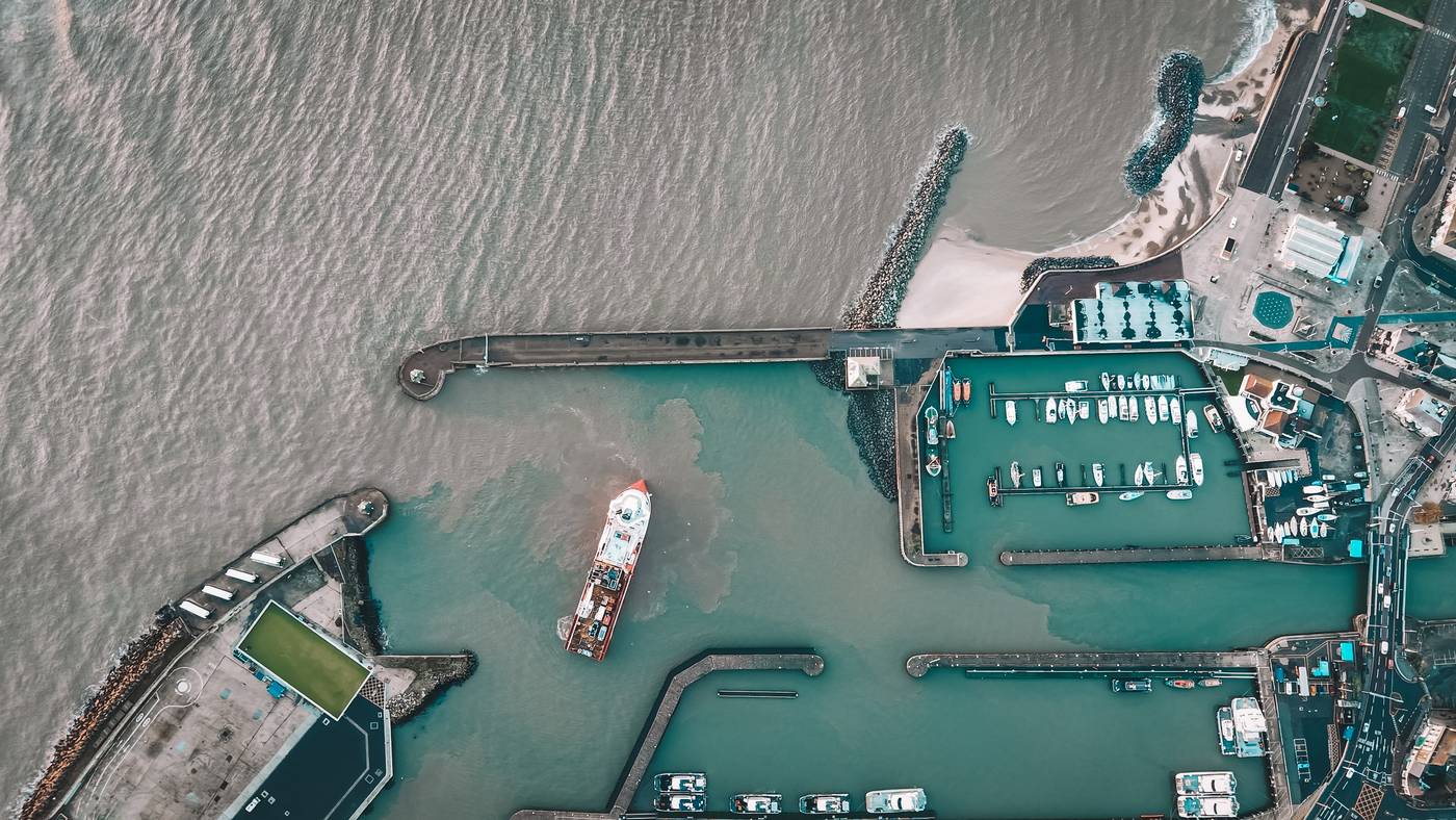 Aerial view looking straight down on the Lowestoft harbour entrance, a vessel passing between the North and South Piers
